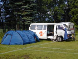 Ein Zelt neben dem Transporter auf einer Wiese