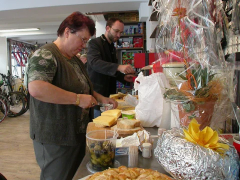 Zwei Personen schneiden Brot an einem Buffet im Laden