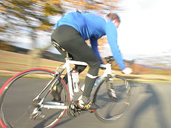 Ein Rennradfahrer in schneller Fahrt, der Hintergrund verwischt