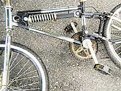 Ein Mountainbike mit Federgabel steht auf Pflaster, Aufnahme in grober Körnung