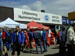 Menschen vor einem Zelt mit der Aufschrift „Utlämning Nummerlappar“