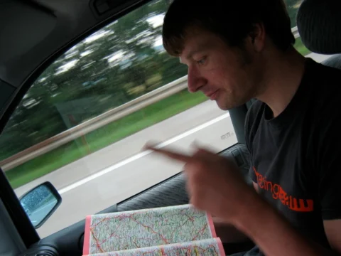 Ein Beifahrer studiert eine Straßenkarte im fahrenden Auto