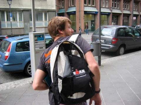 Ein Mann mit Rucksack auf einem Gehweg in der Stadt