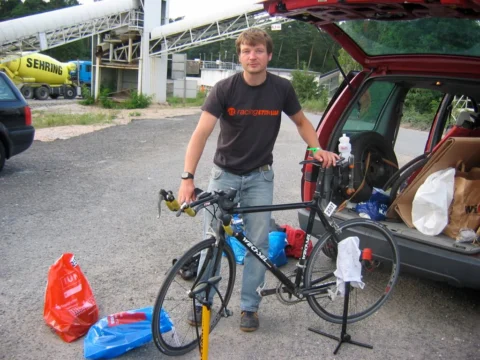 Petz im Trikot des at racing team mit seinem Rennrad am geöffneten Kofferraum