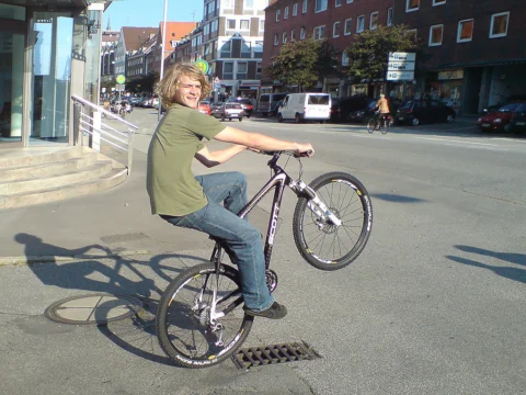 Ein Fahrer macht einen Wheelie auf einer Stadtstraße