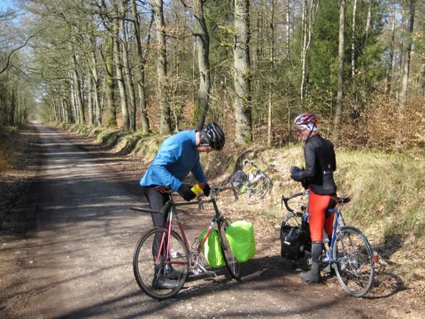 Zwei Fahrer machen Rast auf einem Waldweg, die Räder abgestellt