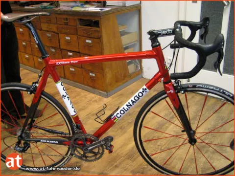 Ein rotes Colnago-Rennrad vor der Schubladenwand im Laden