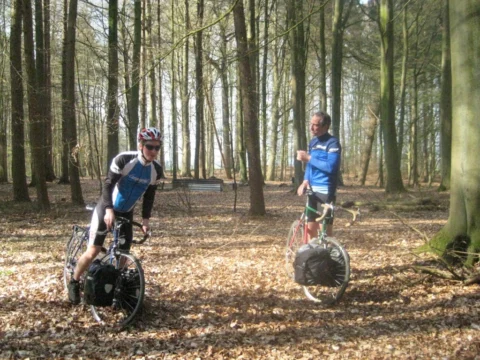 Zwei Fahrer machen Rast auf einem laubbedeckten Waldweg