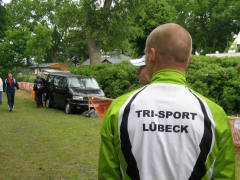 Ein Helfer von hinten, auf der Jacke steht „Tri-Sport Lübeck“
