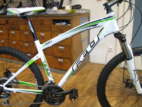 Ein weiß-grünes Felt-Mountainbike vor der Schubladenwand