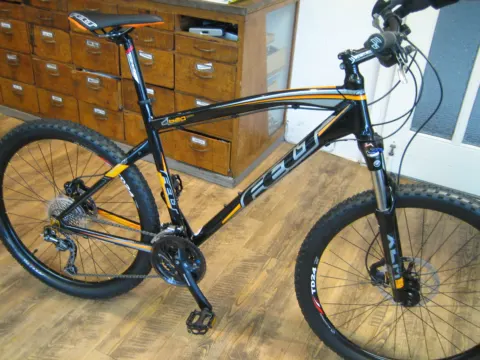 Ein schwarz-gelbes Felt-Mountainbike auf dem Holzboden im Laden