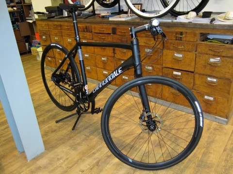 Ein schwarzes Cannondale mit Federgabel vor der Schubladenwand