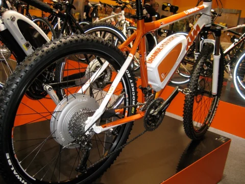 Ein orangefarbenes Mountainbike mit Nabenmotor auf einem Messestand