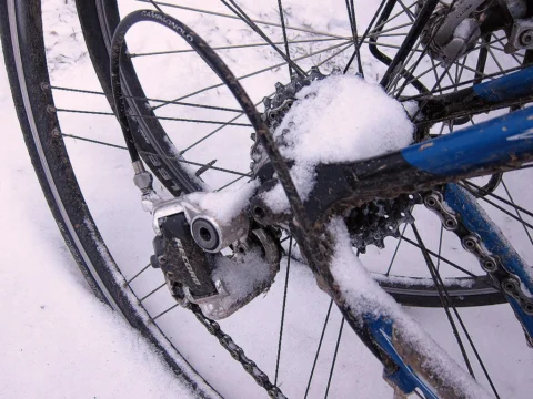 Detail eines Rennrads: Schaltwerk und Kassette dick mit Schnee bedeckt