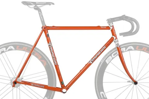 tommasini-tecno-rahmen Ein orangefarbener Rennradrahmen, freigestellt, die Laufräder nur angedeutet