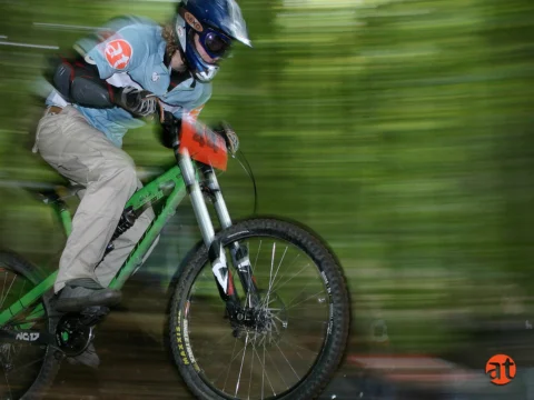 Ein Mountainbiker springt über einen Sprunghügel, der Hintergrund verwischt