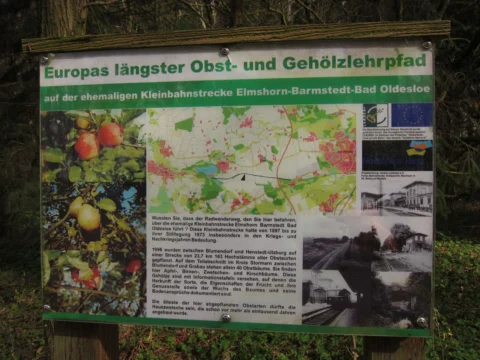 Eine Tafel „Europas längster Obst- und Gehölzlehrpfad“ auf der ehemaligen Kleinbahnstrecke