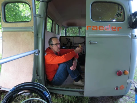 Derselbe Mann im Heck des Transporters, seitlich aufgenommen