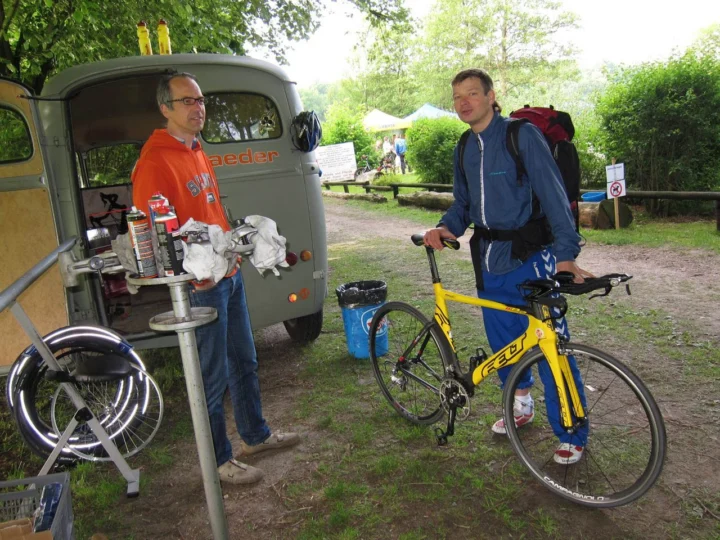 Jens am Montageständer neben dem at Mobil, Petz mit seinem gelben Felt-Zeitfahrrad
