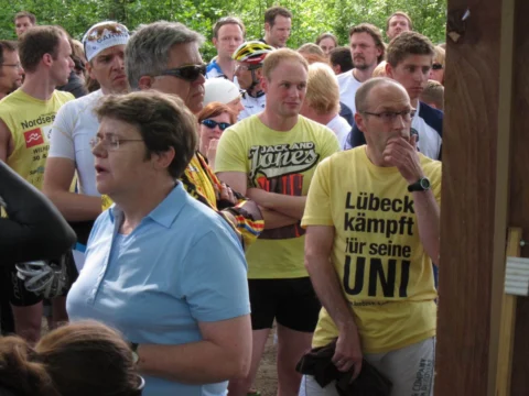 Zuschauer im Gedränge, einer im gelben Shirt „Lübeck kämpft für seine Uni“