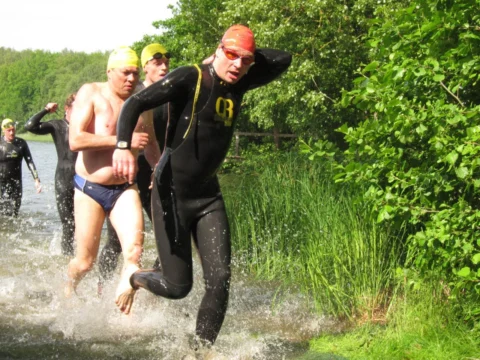 Schwimmer kommen aus dem Wasser und laufen ans Ufer