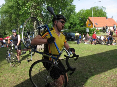 Ein Athlet trägt sein Rennrad durch die Wechselzone