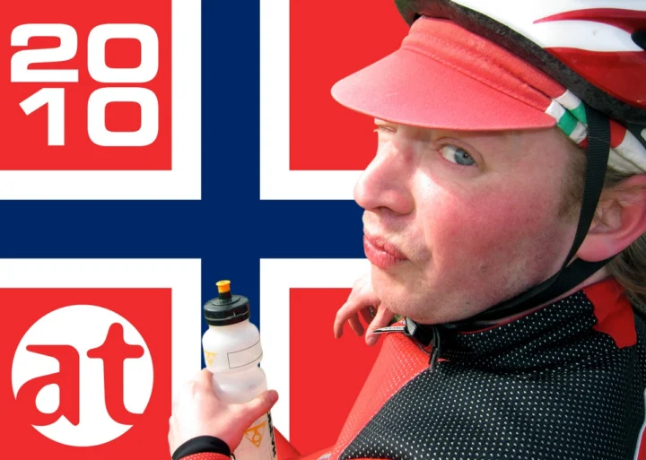 Ein Radfahrer mit Rennmütze und Trinkflasche vor einer Bildmarke mit norwegischer Flagge
