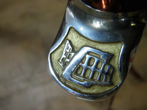 Nahaufnahme eines verchromten Steuerkopfschilds mit vergoldetem Wappen