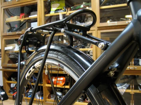 Detail eines Trekkingrads im Laden: Gepäckträger und Schutzblech über dem Hinterrad