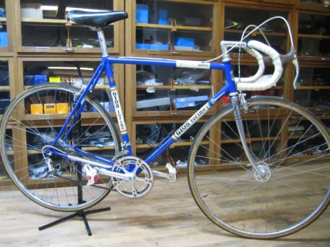 Ein blau-weißes Gios-Rennrad im klassischen Stil im Montageständer der Werkstatt