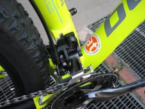 Detail eines neongelben Mountainbikes: Kurbel und Bremssattel am Hinterbau