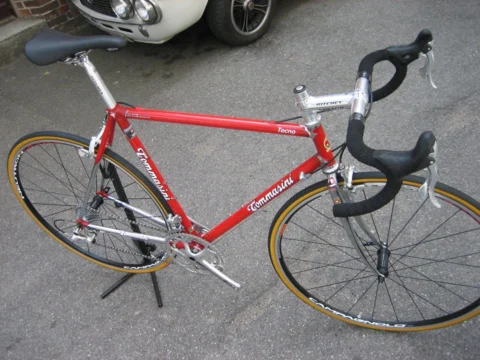Ein rotes Tommasini-Rennrad von der linken Seite auf dem Gehweg