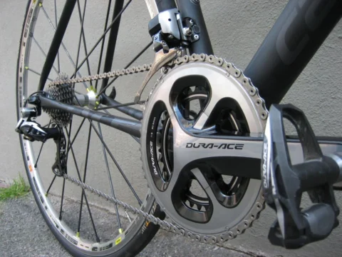 Detail eines Rennrads: Dura-Ace-Kurbel und Umwerfer am grauen Rahmen