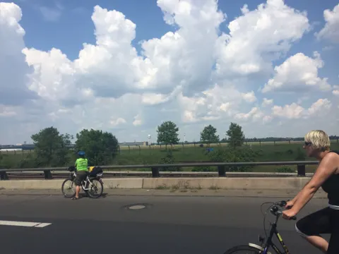 Radfahrende auf der Autobahn, im Vordergrund eine Teilnehmerin von hinten