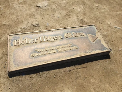 Eine Bronzetafel im Boden mit der Aufschrift „Hoher Hagen 681 m“