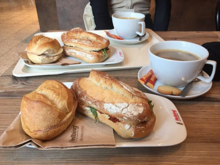 Belegte Brötchen und zwei Tassen Kaffee auf einem Tablett