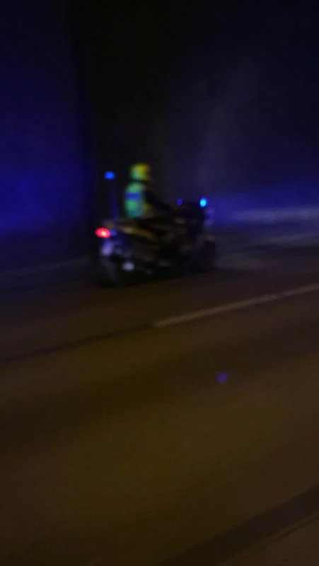 Ein Polizeimotorrad mit Blaulicht im dunklen Tunnel, unscharf aufgenommen