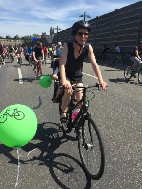 Eine Teilnehmerin fährt auf der abgesperrten Stadtautobahn, daneben schwebt ein grüner Luftballon