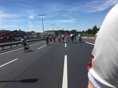 Blick über die Schulter auf eine Gruppe Radfahrender auf der Autobahn
