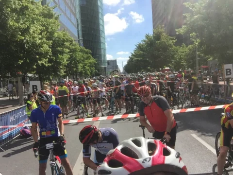 Wartende Fahrer im Startblock auf einer breiten Straße zwischen Bäumen