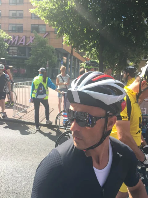 Ein Fahrer mit Helm und Sonnenbrille im Startbereich, dahinter Streckenposten