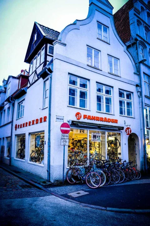Das Ladengeschäft in der Beckergrube: weißes Giebelhaus mit dem Schriftzug at Fahrräder, davor eine Reihe abgestellter Räder