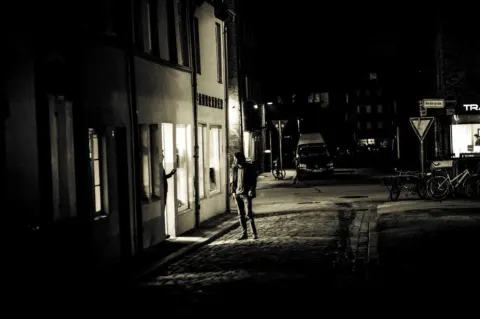 Die Beckergrube bei Nacht, der beleuchtete Laden als einziges Licht in der Gasse