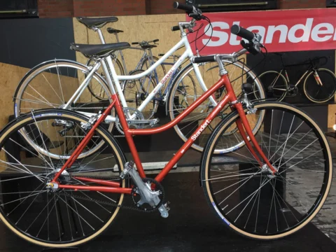 Ein rot-weißes Damenrad im klassischen Stil auf einem Messestand