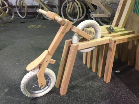 Ein Laufrad für Kinder mit Rahmen aus Holz auf einer Holzkonstruktion