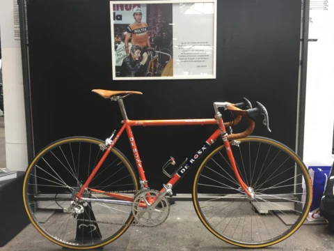 Ein orangefarbenes De-Rosa-Rennrad im Stil der Siebzigerjahre vor einer Fotowand