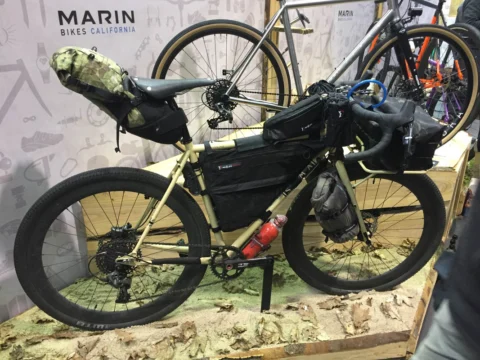 Ein sandfarbenes Marin-Rad mit voller Bikepacking-Ausrüstung auf einem Podest