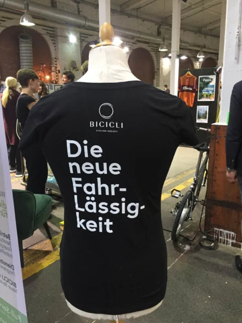 Ein schwarzes T-Shirt auf einer Puppe mit dem Aufdruck „Die neue Fahr-Lässigkeit“
