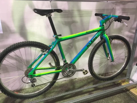 Ein grün-blaues Mountainbike der Neunzigerjahre auf einem Podest