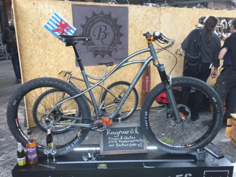 Ein graues Mountainbike mit stolliger Bereifung auf einem Podest